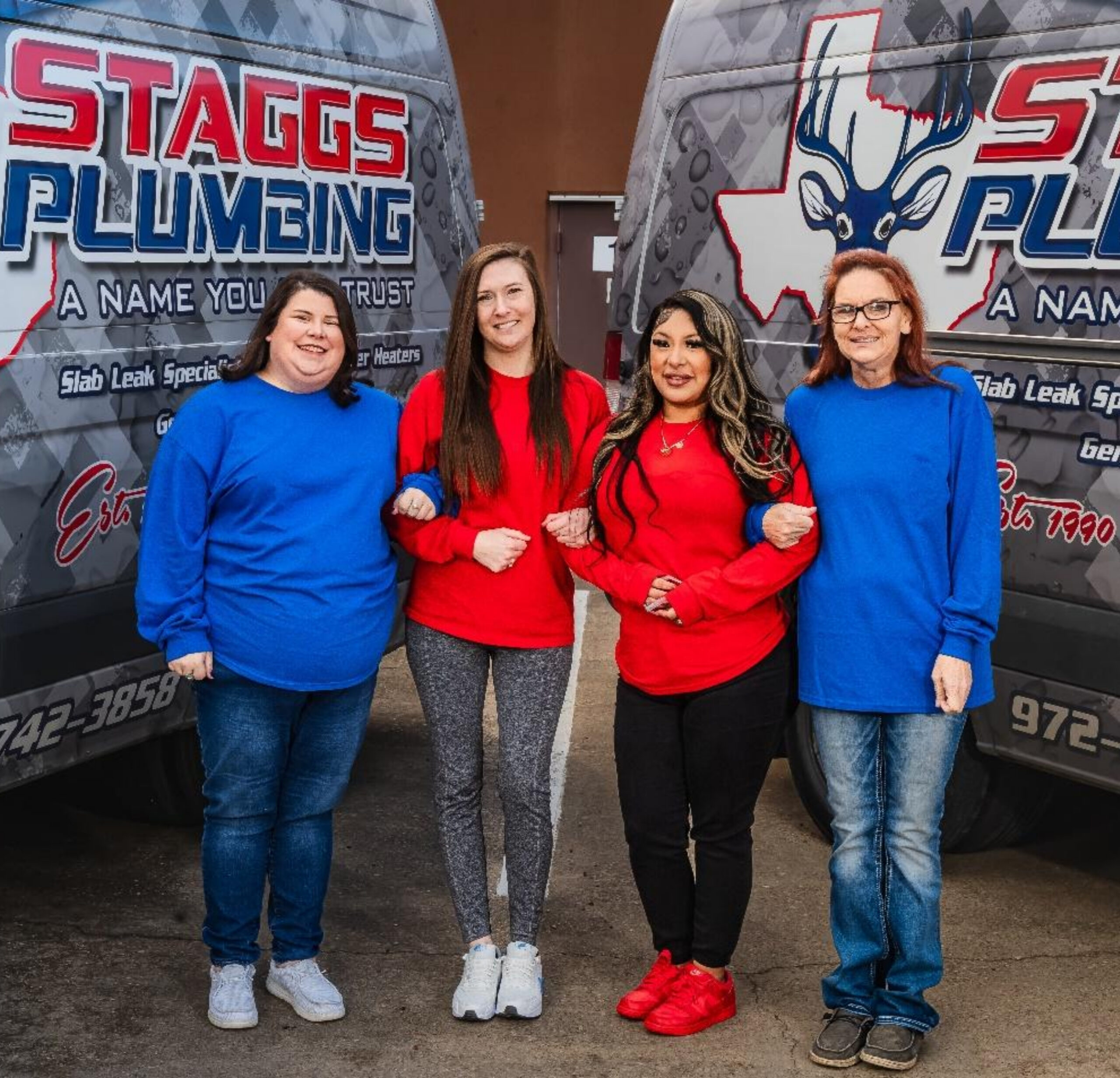 Staggs Plumbing team standing together in front of company service vans